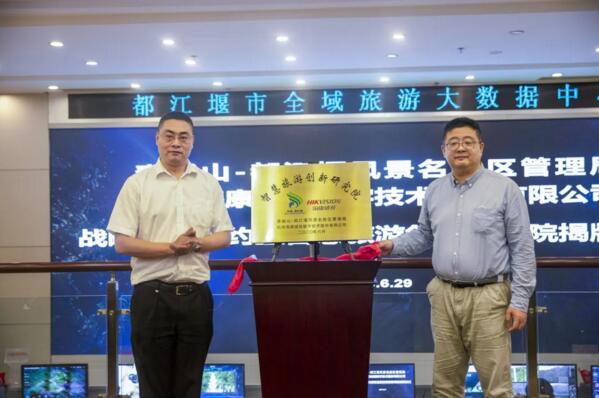 江堰市委常委、宣传部部长唐小峰与海康威视高级副总裁徐习明为“智慧旅游创新研究院”揭牌