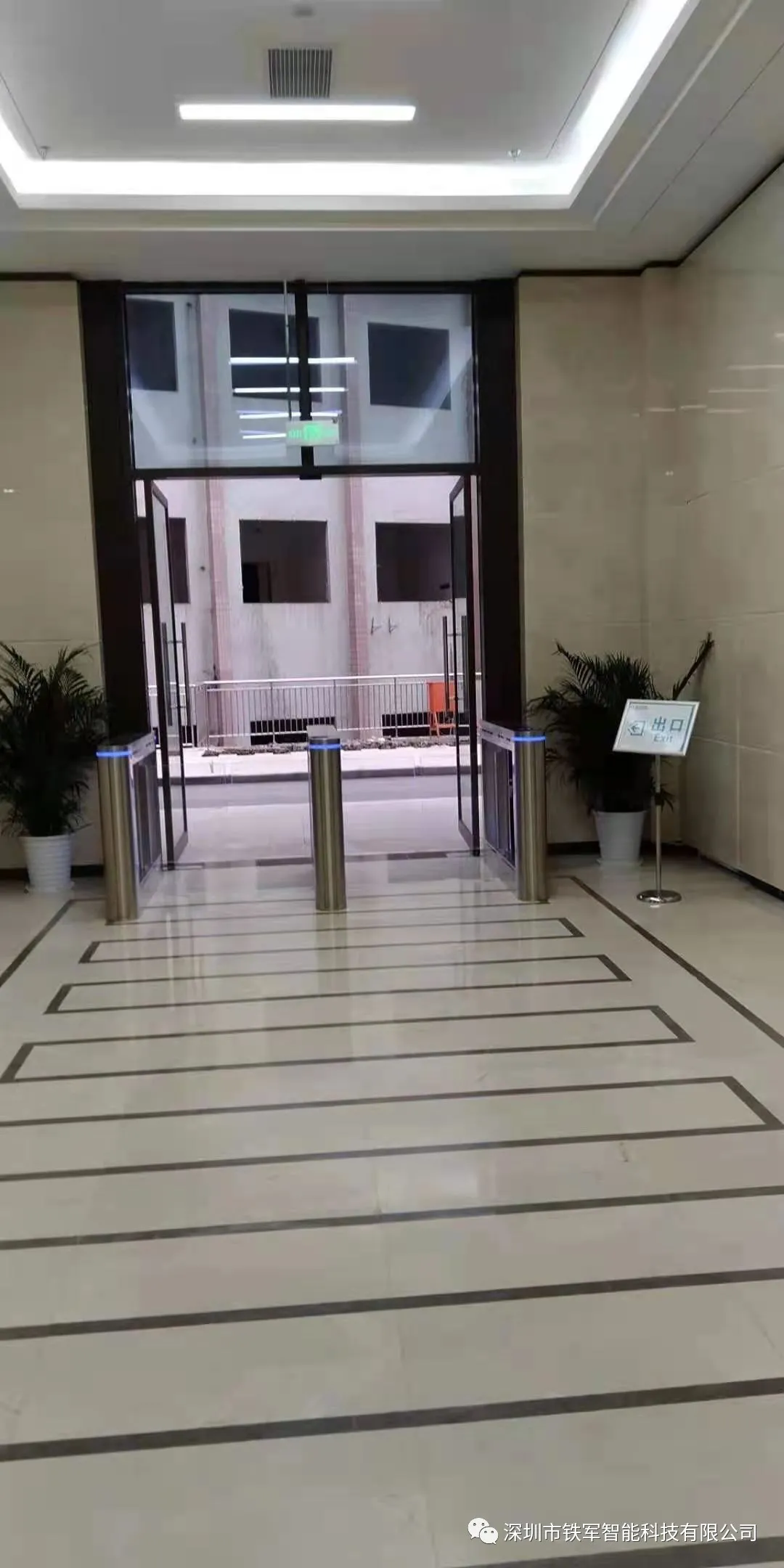 工作人员用“铁军智能”的豪华摆闸加健康码测温人脸识别一体机